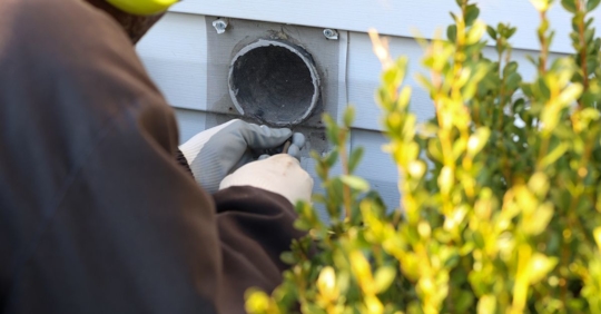 Man Replacing A Mesh Covering Over A Dryer Vent