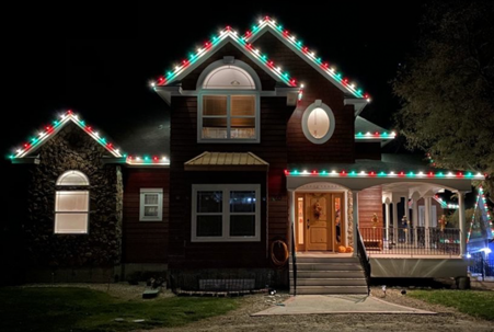 Red and green bulbs line the roof, creating a festive holiday display.